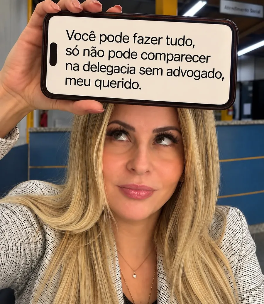 Dra. Daniela Fernandes segurando o celular com um aviso sobre delegacia
